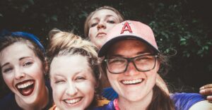 A joyful group of women taking a selfie outdoors, showcasing happiness and friendship.